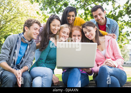 College students using laptop in park Stock Photo