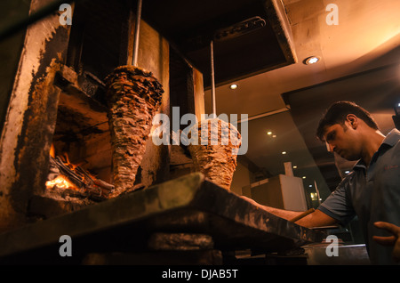 A person attends a Kebab shop in the streets of Deira. Dubai, United Arab Emirates. Stock Photo