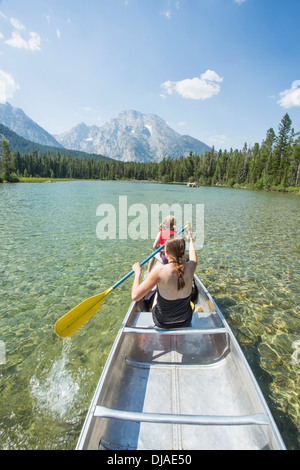 Caucasian mother and daughter paddling canoe on lake Stock Photo