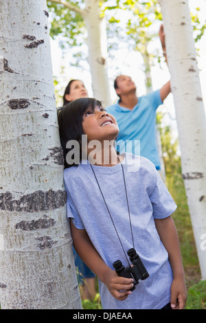 Boy with binoculars in forest Stock Photo