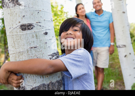 Boy hugging tree outdoors Stock Photo