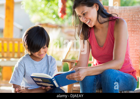 Mother and son reading together on porch Stock Photo