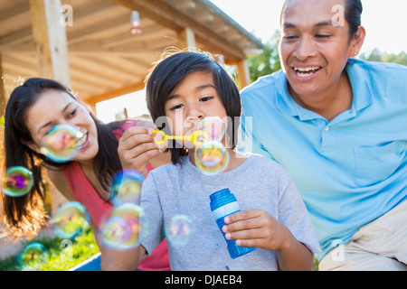Family blowing bubbles outdoors