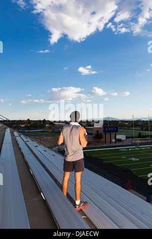 Hispanic athlete standing on bleachers Stock Photo