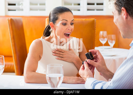 Man proposing to girlfriend at restaurant Stock Photo