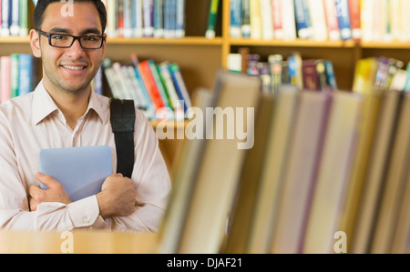 Smiling mature student with tablet PC in library Stock Photo