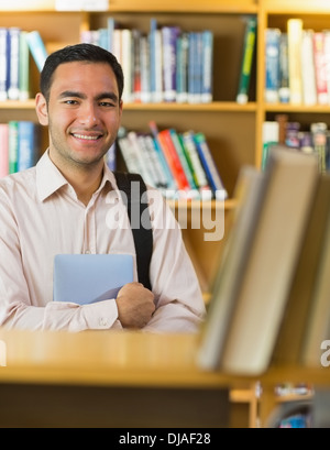 Smiling mature student with tablet PC in library Stock Photo