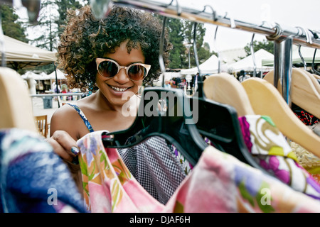 Mixed race woman shopping at flea market Stock Photo