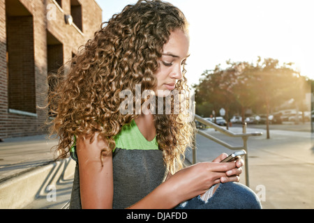 Mixed race girl using cell phone Stock Photo