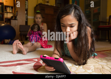 Mixed race girl using digital tablet on floor Stock Photo