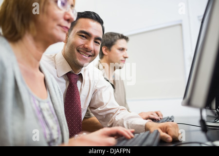Teacher and mature students in computer room Stock Photo