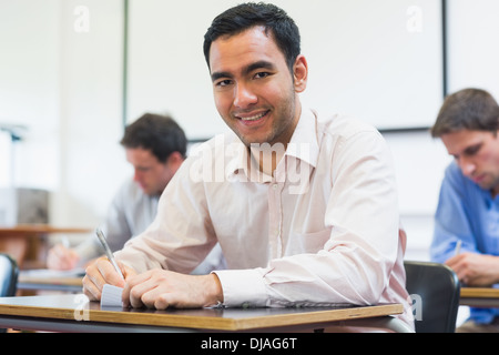 Mature students taking notes in classroom Stock Photo