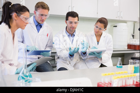 Scientists with tablet PC working on an experiment at lab Stock Photo