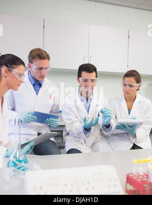 Scientists with tablet PC working on an experiment at lab Stock Photo