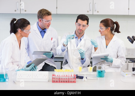 Scientists with tablet PC working on experiment at lab Stock Photo