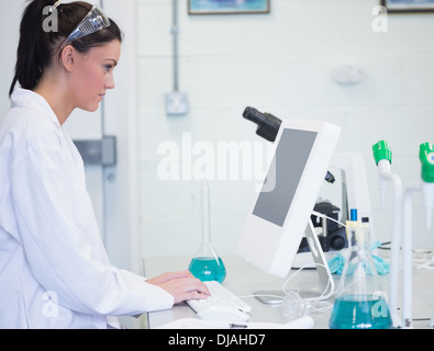 Young female researcher using computer in lab Stock Photo