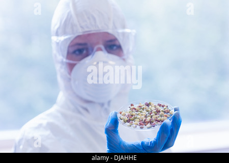 Scientist in protective suit with sprouts Stock Photo