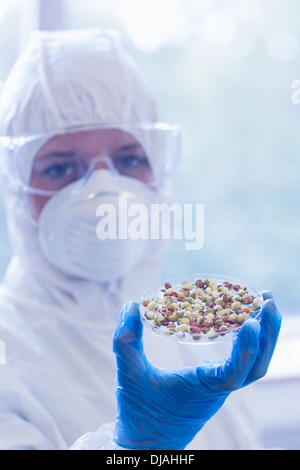 Scientist in protective suit with sprouts in laboratory Stock Photo