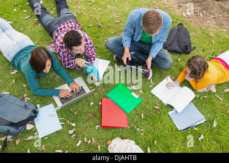 College students using laptop while doing homework in park Stock Photo