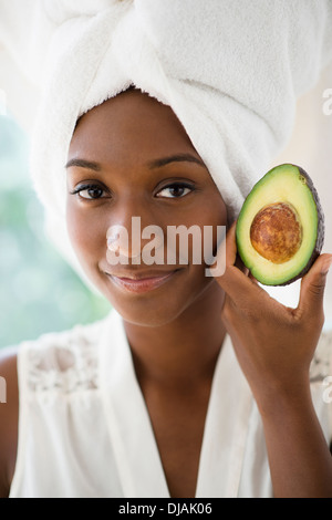 Black woman holding sliced avocado Stock Photo