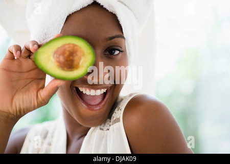 Black woman holding sliced avocado Stock Photo