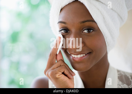 Black woman wiping face with cotton pad Stock Photo