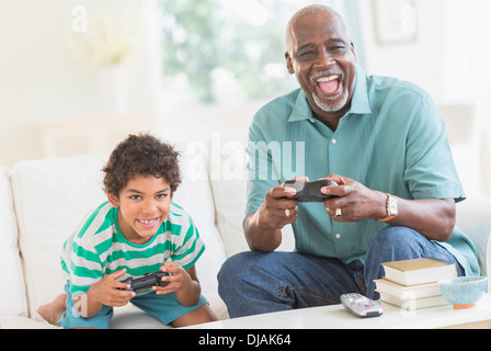 Boy playing video games with grandfather Stock Photo