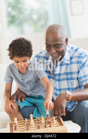 Boy playing chess with grandfather Stock Photo