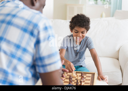 Boy playing chess with grandfather Stock Photo