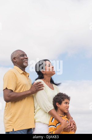 Three generations of family smiling outdoors Stock Photo