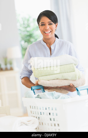 Black woman folding laundry Stock Photo