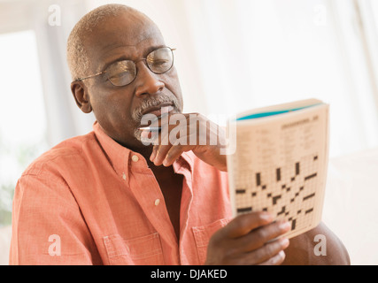 Black man doing crossword puzzle Stock Photo