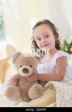 Mixed race girl holding teddy bear Stock Photo