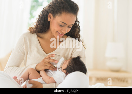 Hispanic mother feeding newborn baby Stock Photo