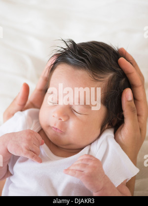 Hispanic mother cradling baby Stock Photo