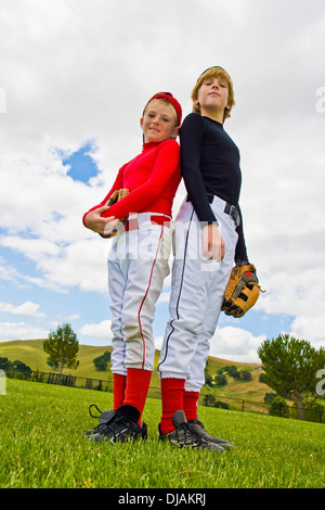 Baseball players standing back to back in field Stock Photo
