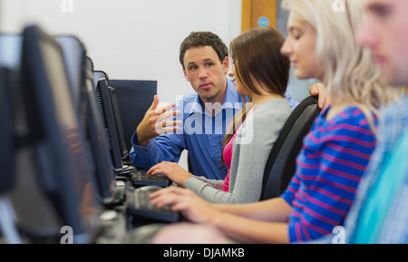 Teacher explaining to students in the computer room Stock Photo