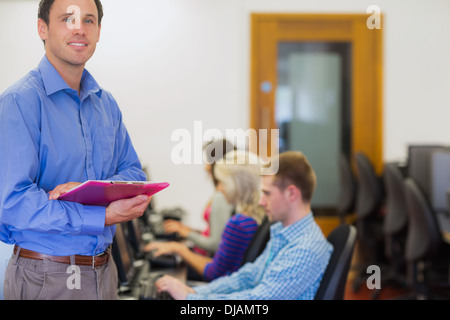 Teacher with students using computers in computer room Stock Photo