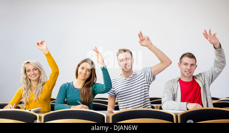 College students raising hands in the classroom Stock Photo