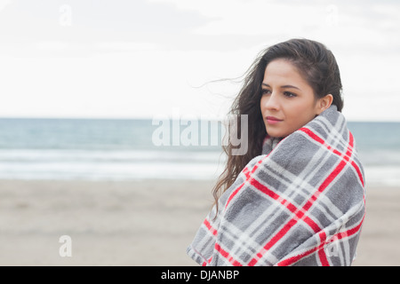 Side view of a woman covered with blanket at beach Stock Photo