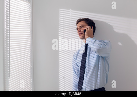 Serious young businessman using mobile phone Stock Photo