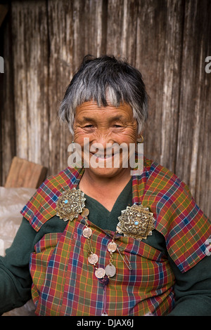 Bhutan, Nobding, smiling old woman in traditional kira with old silver korma brooch Stock Photo