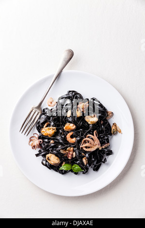 Black pasta with seafood on white plate Stock Photo