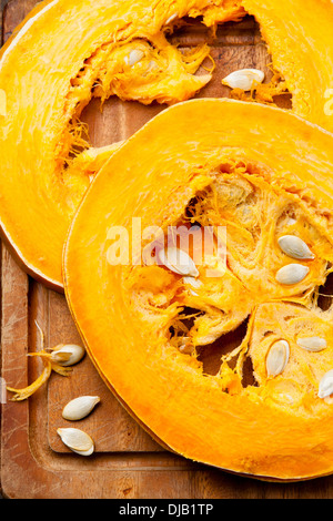 Cut a piece of ripe pumpkin on wooden background Stock Photo