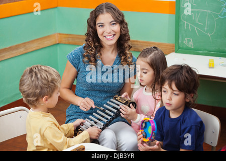 Teacher Playing Xylophone With Students In Preschool Stock Photo