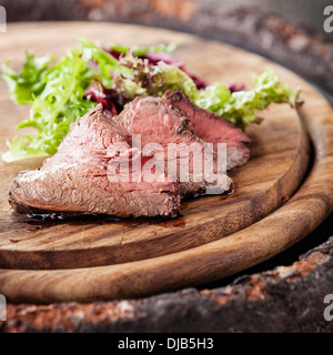 Roast beef on cutting board with lettuce Stock Photo