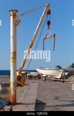 White fishing boat and small crane in port of Petrovac town, Montenegro Stock Photo