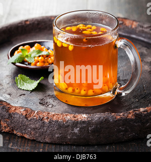 Tea with sea buckthorn on dark background Stock Photo