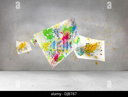 Sheets with graphics and splashes over grey wall Stock Photo