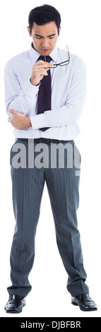 Unsmiling businessman holding glasses Stock Photo